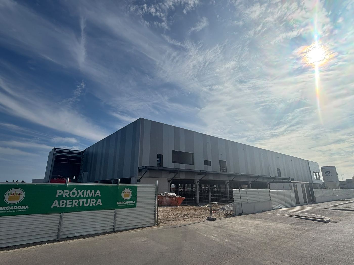 Supermercado com fachada metálica e placa de próxima abertura